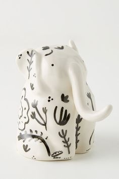 an elephant figurine with black and white designs on it's trunk, sitting in front of a white background