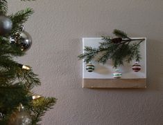 christmas ornaments hanging on the wall next to a tree