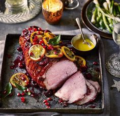 sliced meat with cranberry sauce and garnishes on a platter