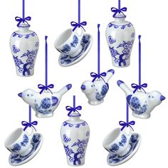 six ceramic teapots and saucers with blue bows hanging from the top one is shaped like a bird