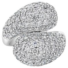 A fashionable and chic ring, showcasing 118 round brilliant cut diamonds weighing 5.69 carats total, micropavé set with a timeless domed bypass design. Finely made with 18K white gold, 0.94 inch in width and 0.31 inch in depth. Size 7.75 US, resizable upon request. Roman Malakov is a custom house, specializing in creating anything you can imagine. If you would like to receive a special quote on a custom piece, please message or call us. Pave Bangle, Chic Rings, Bold Rings, Unique Diamond Rings, Pave Diamond Ring, Bypass Ring, Unique Diamonds, Domed Ring, Gold Diamond Rings