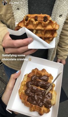 two waffles with chocolate on top are being held by someone