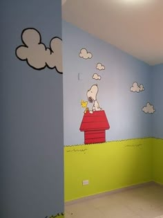 a room painted in blue and green with a snoopy dog on the top of a house