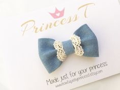 a blue and white bow with lace on it's side sitting on top of a card