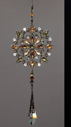 an ornate metal wind chime with multicolored crystals