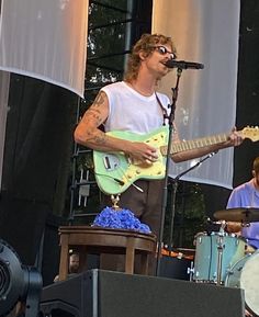 the man is playing his guitar on stage