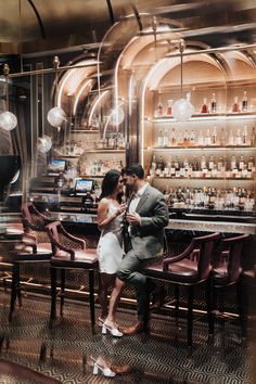 a man and woman standing in front of a bar