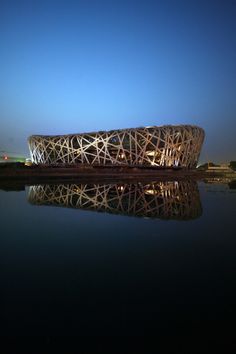 the building is made out of sticks and has a large body of water in front of it