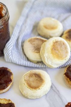 some biscuits and jam on a table with a blue towel next to them in the background