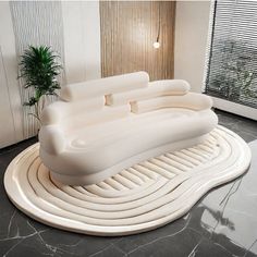 an inflatable couch sitting on top of a black and white floor next to a potted plant