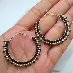 Elegant and unique dangle earrings in gold and black colours. Gold and black handwoven Miyuki beads on a gold plated hoop.  These can also be made in silver instead of gold, choose the option in the drop down menu.  The size of each hoop is approx. 3.8cm All jewellery comes gift wrapped and in black velvet drawstring bags, whether it is for a loved one or a treat for yourself. If you would like to include a hand written message just include a note in your order. Jewellery will be posted with tracking the next business day after placing order. Please note colours may vary slightly due to viewing device or monitor. *CARE TIPS* Take your jewellery off if you are involved in any activity which could scratch, knock or damage it. If in any doubt, take it off and keep it safe. Keep it well away f Handmade Metal Hoop Earrings With Round Beads, Gold Beaded Brass Hoop Earrings, Handmade Black Brass Jewelry, Handmade Round Metal Beaded Earrings, Gold Beaded Earrings With Black Beads As Gift, Minimalist Handmade Black Hoop Earrings, Black Minimalist Handmade Hoop Earrings, Adjustable Black Beaded Hoop Jewelry, Bohemian Gold Beaded Circle Earrings