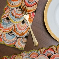 there is a plate, fork and napkin next to the placemats on the table