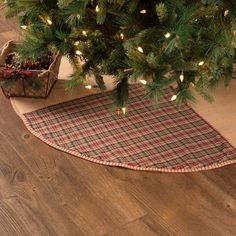 a christmas tree skirt is on the floor next to a potted plant in a basket