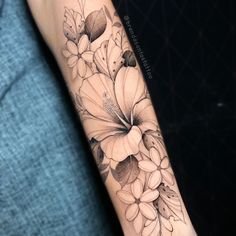 a black and white flower tattoo on the arm