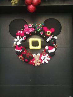 a mickey mouse wreath is hanging on the front door to decorate it with christmas decorations