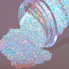 a bottle filled with glitter sitting on top of a table