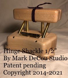 a wooden stamper with a string tied around it and the words hinge shackle 1 / 2 by mark degou - studio