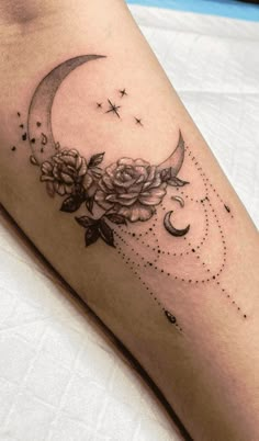 a woman's leg with a crescent and roses tattoo on the left side of her arm