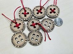 six wooden buttons with red string hanging from them