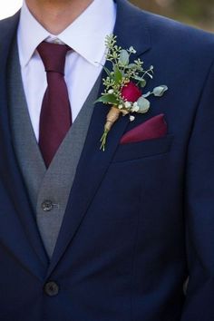 a man in a suit and tie with a boutonniere on his lapel