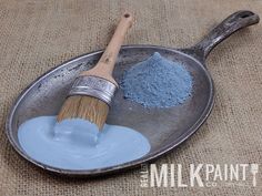 a metal pan filled with blue powder and a wooden brush