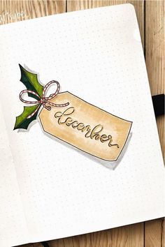 a notepad with a christmas tag on it and the word december written in cursive writing