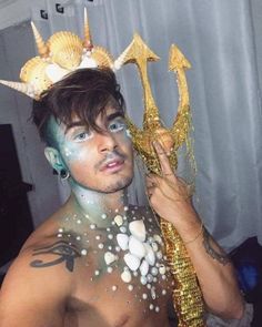 a man with his body painted gold and wearing a crown on top of his head