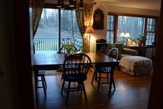 a dining room table and chairs in front of a sliding glass door that leads to a deck