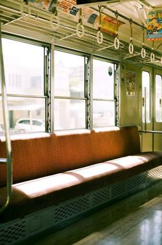 the inside of a train car with lots of windows and red bench in front of it