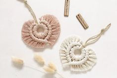 three pieces of yarn are arranged on a white surface, including one heart and two crochet hooks