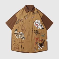 Front view of the brown unisex embroidered cat short sleeve shirt in brown Embroidered Cat, Costume Bags, Cat Embroidery, Outwear Coat, Overalls Pants, Floral Print Shirt, Cat Shirt, Trendy Style, Short Sleeve Button Up