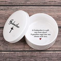 two white bowls with the words, the godchilds and a cross on them