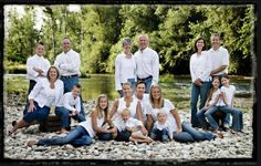 a large group of people posing for a photo in front of a body of water