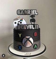 a cake that is decorated with video game controllers and the words gabril eleven below it