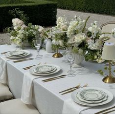 the table is set with white and gold place settings