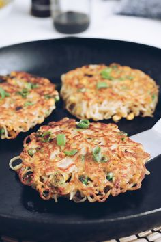 three fritters are sitting on a black plate