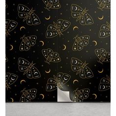 a black and gold wallpaper with moths, stars and crescents on it's sides