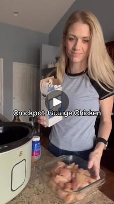 a woman standing in front of a crockpot with chicken