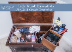 an open trunk filled with assorted items on top of a floor next to a wall