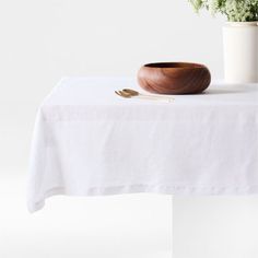 a wooden bowl sitting on top of a white table