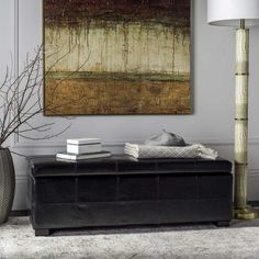 a living room with a large painting on the wall and a black bench in front of it