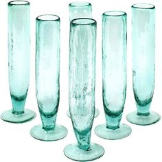 four tall glass vases sitting next to each other