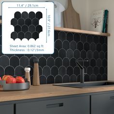 a kitchen with black and white tiles on the backsplash next to a bowl of fruit