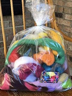 a plastic bag filled with lots of different colored items on top of a wooden table