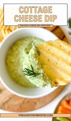 a hand holding up a piece of bread that has been dipped with guacamole dip