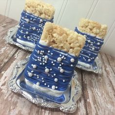 two blue and white cakes sitting on top of a silver tray next to each other