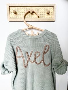 SWEATER IS OVERSIZED. Size down for a true oversized fit Personalized Hand-Embroidered Baby and Toddler Sweaters Our charming hand-embroidered "Name" sweaters are the ideal choice for commemorating special moments such as birth announcements, newborn and family photos, baby shower gifts, birthdays, or any memorable occasion! Each embroidery is meticulously crafted by hand, making every sweater a unique and one-of-a-kind masterpiece. You can customize the sweater with your baby's name, select your preferred sweater color, and embroidery color. **Please provide all the custom information for your order in the personalization box at checkout. Refer to the listing photos for available sweater and yarn colors. The size of the embroidery/letters may vary depending on the number of letters and sw Oversized Winter Sweater With Letter Embroidery, Personalized Cotton Sweater For Winter, Cute Winter Sweater With Letter Embroidery, Cute Winter Sweater With Embroidered Text, Oversized Winter Sweater With Embroidered Text, Cute Custom Embroidered Sweater For Winter, Cute Sweater With Letter Embroidery For Fall, Cute Letter Embroidery Sweater For Fall, Name Sweater Baby