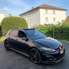 a black car parked in front of a house