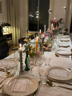 a table set with place settings and candles