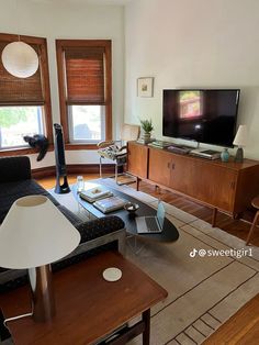 a living room filled with furniture and a flat screen tv on top of a wooden entertainment center